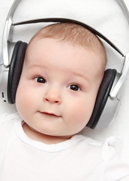 baby with headphone lies on back
